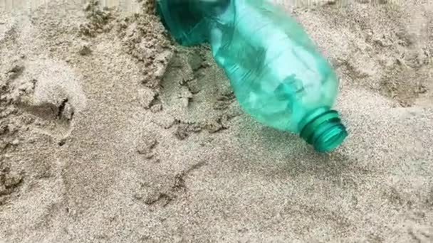Une bouteille vide en plastique vert jetée sur une plage. Pollution côtière — Video