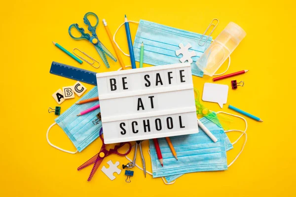 Esteja seguro na mensagem da escola com equipamentos escolares e máscaras vívidas — Fotografia de Stock