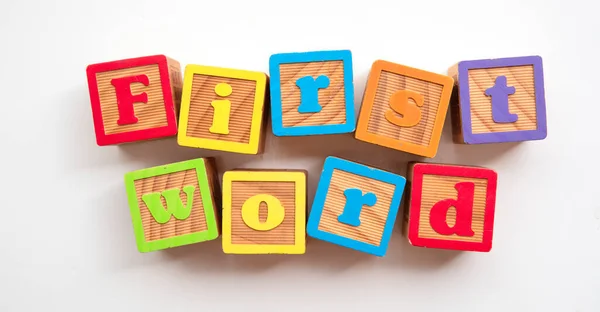 Premier mot fait à partir de blocs de développement de bébé en bois coloré — Photo
