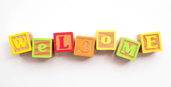 Palabra de bienvenida hecha de bloques de desarrollo de bebés de madera coloridos — Foto de Stock