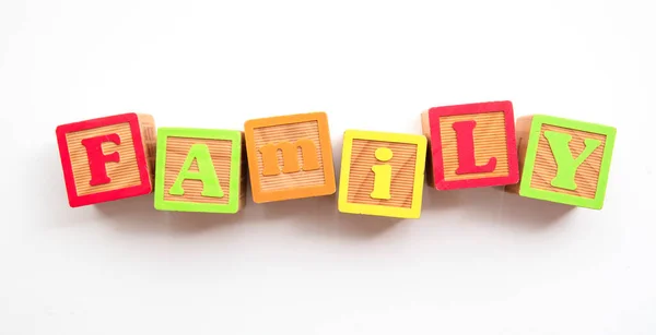 Family word made from colourful wooden baby development blocks — Stock Photo, Image