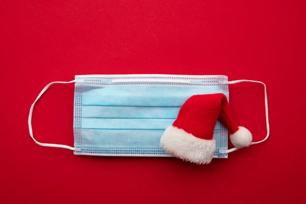 Kerstman hoed op een beschermende coronavirus gezichtsmasker — Stockfoto