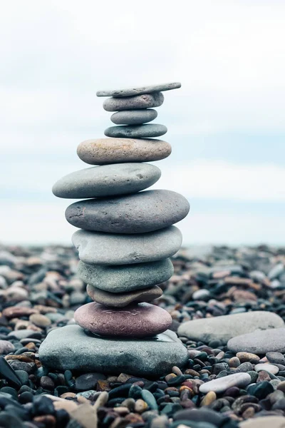 relaxation at sea. Stack of stones on beach close up. Stone cairn on sea blurry background, pebbles and stones. Concept balance