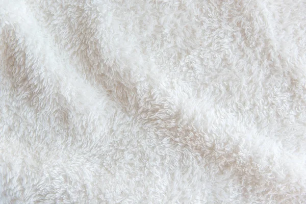White delicate soft background of plush fabric. Texture of beige soft fleecy blanket