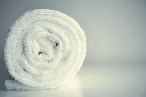 Clean white towel rolled blanket textile on light blurred backgr
