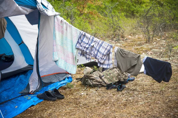 tourist tent camping in forest. Tourist life - clothes are dried, the guitar stands near the ten