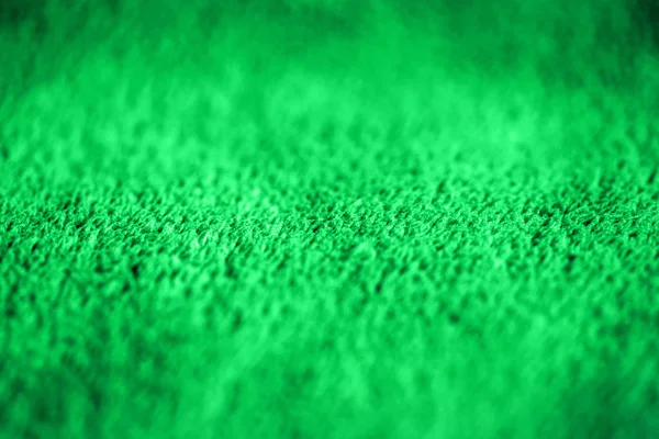 Green delicate soft background of fur plush smooth fabric. Texture of purple soft fleecy blanket textile