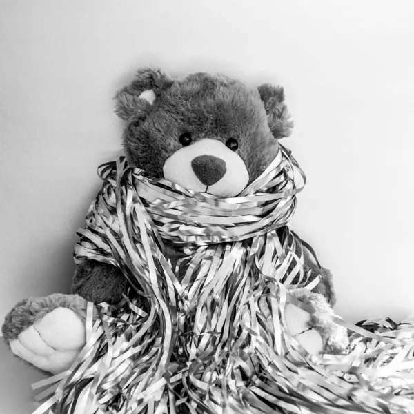 Christmas composition with stuffed toy teddy bear. Black and white square photo