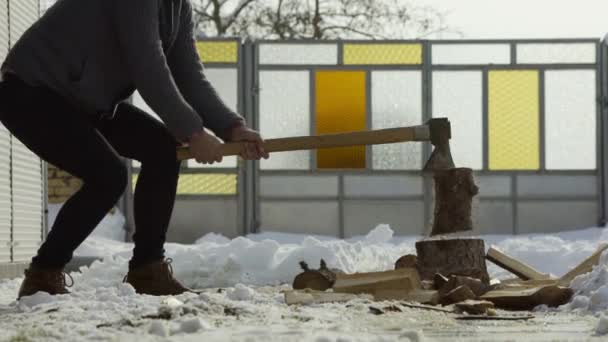 雪の庭冬村で木を割って男 — ストック動画