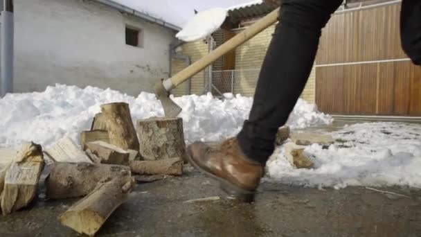 雪の庭冬村で木を割って男 — ストック動画