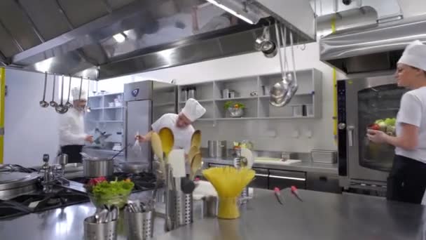 シェフかき立てるスープ鍋料理では サラダを作るを助けています — ストック動画