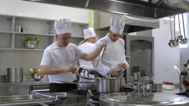 主厨搅拌汤在一个酱油厨师帮助制作沙拉 — 图库视频影像