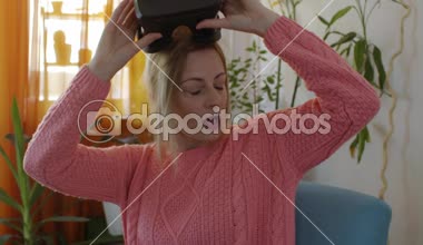 sanal gerçeklik gözlükleri modern armchairlooking kullanılarak ve hareketleri el ile kullanarak pembe kazak evde kadında zevk