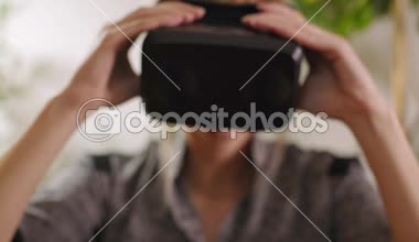 sanal gerçeklik gözlükleri ayarlama ve onları koyarak genç kadın