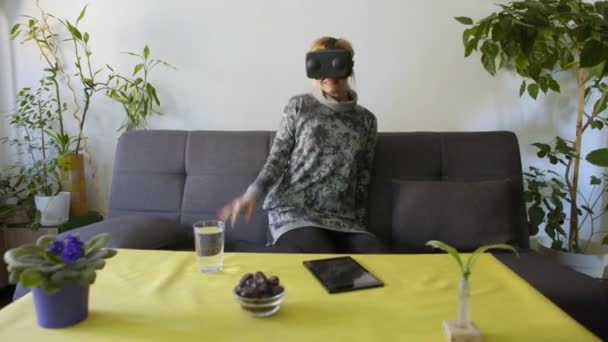 Женщина Дома Боится Используя Очки Виртуальной Реальности Sofalooking Вокруг Помощью — стоковое видео