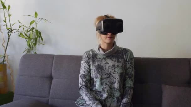 Жінка Вдома Боїться Використовувати Окуляри Віртуальної Реальності Дивані Дивлячись Навколо — стокове відео