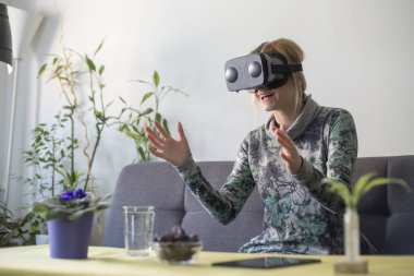 zevk sanal gerçeklik gözlükler kanepede kadın evde etrafında arıyorsunuz ve hareketleri el ile kullanarak