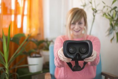 genç kadın sanal gerçeklik koyarak içinde kamera için koruyucu gözlük