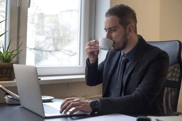 Businessman Drinking Coffee Working Laptop Office Taking Notes Window Black — Stock Photo, Image