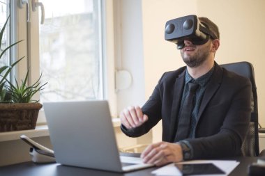 işadamı işini bitirir ve notebook kağıtları telefon Vr ile pencere siyah masasının üzerinde alarak sanal gerçeklik koruyucu gözlük