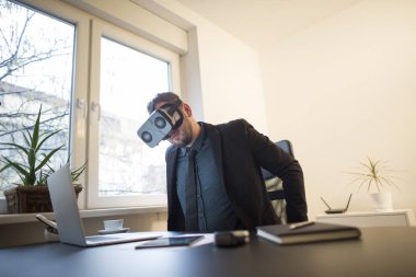 işadamı işini bitirir ve notebook kağıtları telefon Vr ile pencere siyah masasının üzerinde alarak sanal gerçeklik koruyucu gözlük