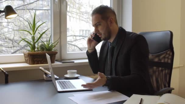 ノート ペーパー電話執行役員経営と黒のウィンドウの表によって緊張と怒り電話を行うオフィスでラップトップに取り組んでの実業家 — ストック動画