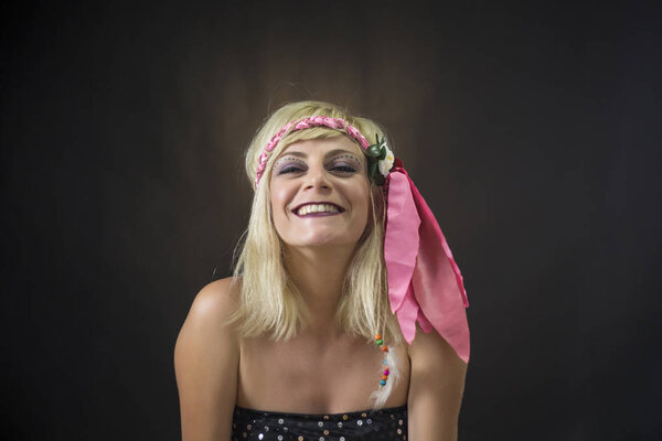 Portrait of beautiful young blonde woman wearing hippie headband on black background