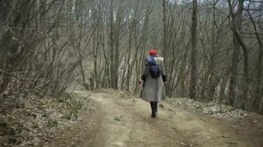 Kırmızı şapkalı forestyoung çekici kadın genç çekici kadın kırmızı şapka ile dolaşır ve kırmızı etek yalak kalın orman giden yol dolaşır. Kışın ormanda yürüyüş erkek