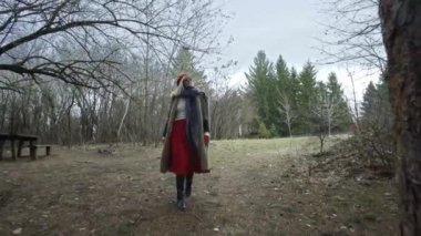 Kırmızı şapkalı ağaç genç çekici kadına dokunmak ormandaki genç çekici kadın kırmızı şapka ile dolaşır ve kırmızı etek yalak kalın orman giden yol dolaşır. Kışın ormanda yürüyüş erkek