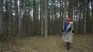 Kırmızı şapkalı ağaç genç çekici kadına dokunmak ormandaki genç çekici kadın kırmızı şapka ile dolaşır ve kırmızı etek yalak kalın orman giden yol dolaşır. Kışın ormanda yürüyüş erkek