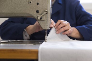 Kanepe için malzeme dikiş yaşlı bir kadınla bir mobilya fabrikasında closeup