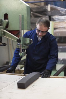 Kanepe için köpük kesme bir mobilya fabrikasında genç bir adam portresi