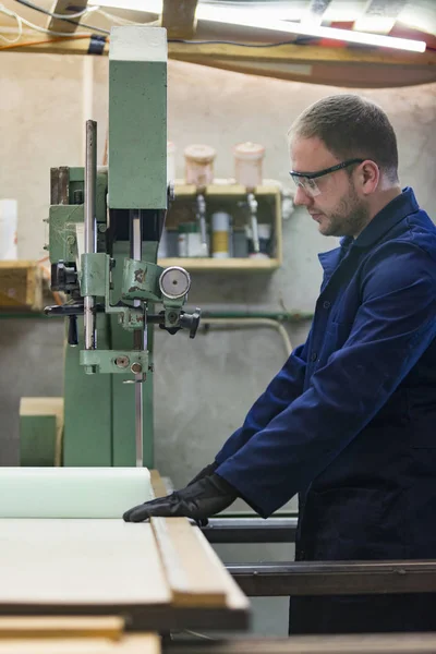 Портрет молодого человека на мебельной фабрике, разрезающего пену для дивана — стоковое фото
