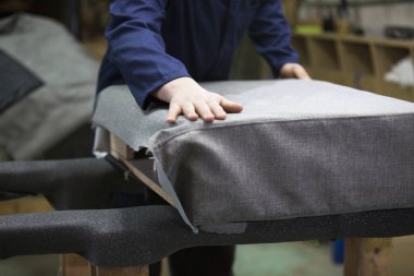 Bir mobilya fabrikasında birlikte kanepe ve bir kısım koyar bir delikanlı closeup