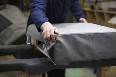 Bir mobilya fabrikasında birlikte kanepe ve bir kısım koyar bir delikanlı closeup