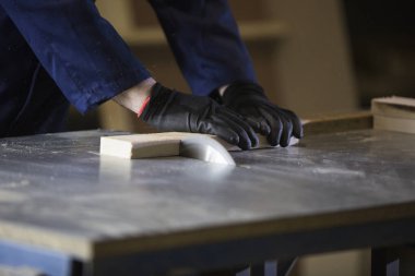 Bir gencin kanepede için ahşap parçalar kesilmesi bir mobilya fabrikasında yakın çekim