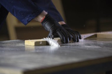 Bir gencin kanepede için ahşap parçalar kesilmesi bir mobilya fabrikasında yakın çekim