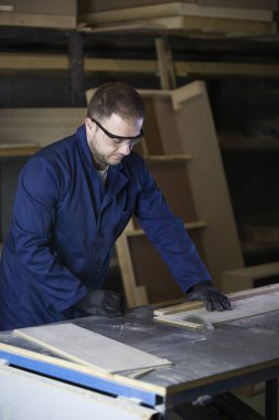 Kanepe için ahşap parçalar kesilmesi bir mobilya fabrikasında genç adam
