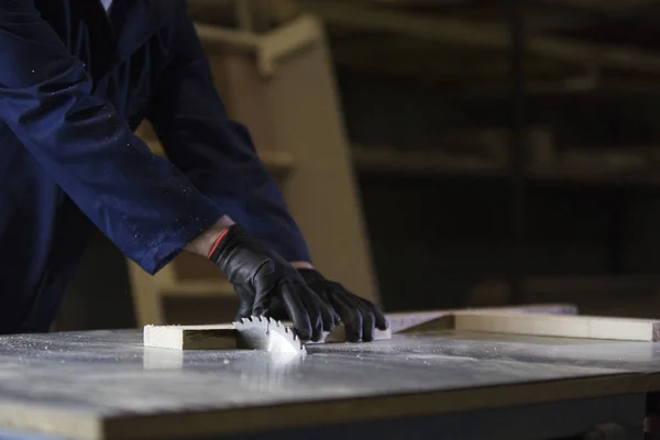 Close up van een jonge man in een meubelfabriek snijden de houten stukken voor de Bank — Stockfoto