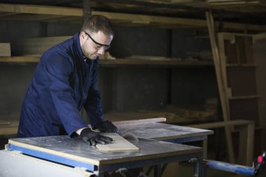 Kanepe için ahşap parçalar kesilmesi bir mobilya fabrikasında genç adam