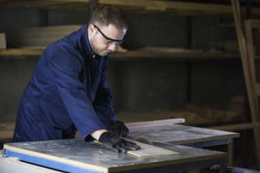 Kanepe için ahşap parçalar kesilmesi bir mobilya fabrikasında genç adam