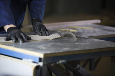 Bir gencin kanepede için ahşap parçalar kesilmesi bir mobilya fabrikasında yakın çekim