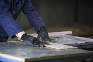 Bir gencin kanepede için ahşap parçalar kesilmesi bir mobilya fabrikasında yakın çekim