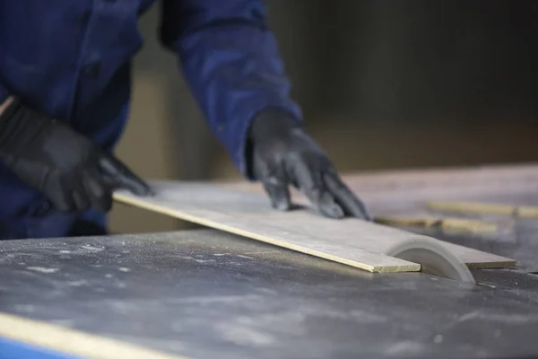 Close up van een jonge man in een meubelfabriek snijden de houten stukken voor de Bank — Stockfoto