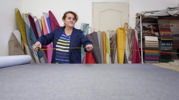 Older Woman Dark Coat Measures Marks Grey Material Sofa Chock — Stock Video