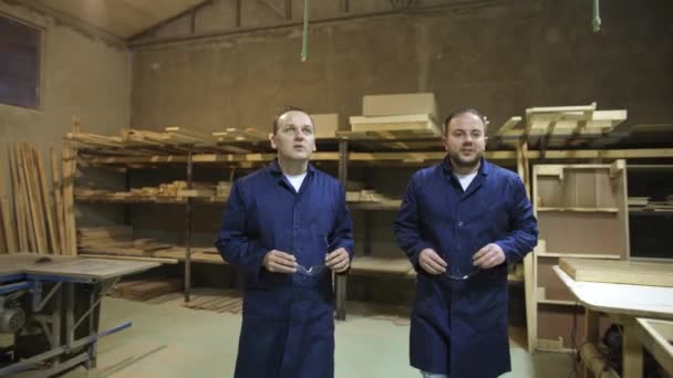 Dos Trabajadores Con Gafas Seguridad Caminando Hablando Una Fábrica Muebles — Vídeos de Stock