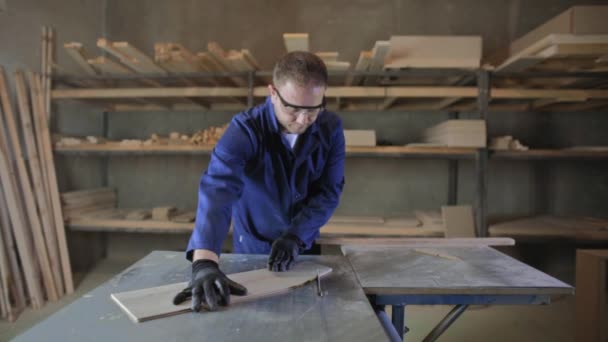 Ung Man Mörk Päls Skär Trä Bitar Till Soffan Skärmaskin — Stockvideo