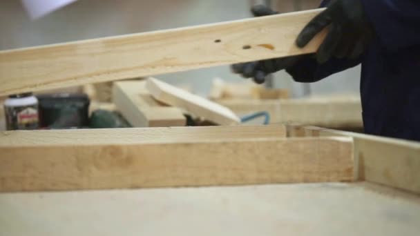 Młody Człowiek Ciemnym Płaszczu Umieszcza Razem Drewniane Elementy Sofa Biurko — Wideo stockowe