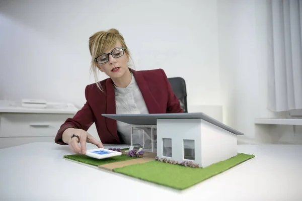 Une femme architecte regardant une maison modèle — Photo