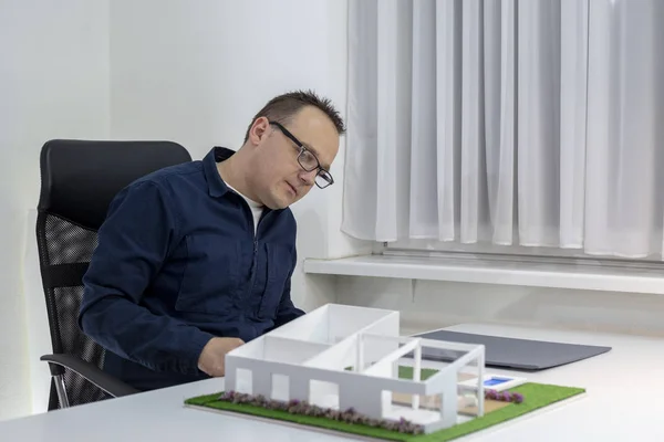 Архитектор смотрит на образцовый дом в офисе — стоковое фото